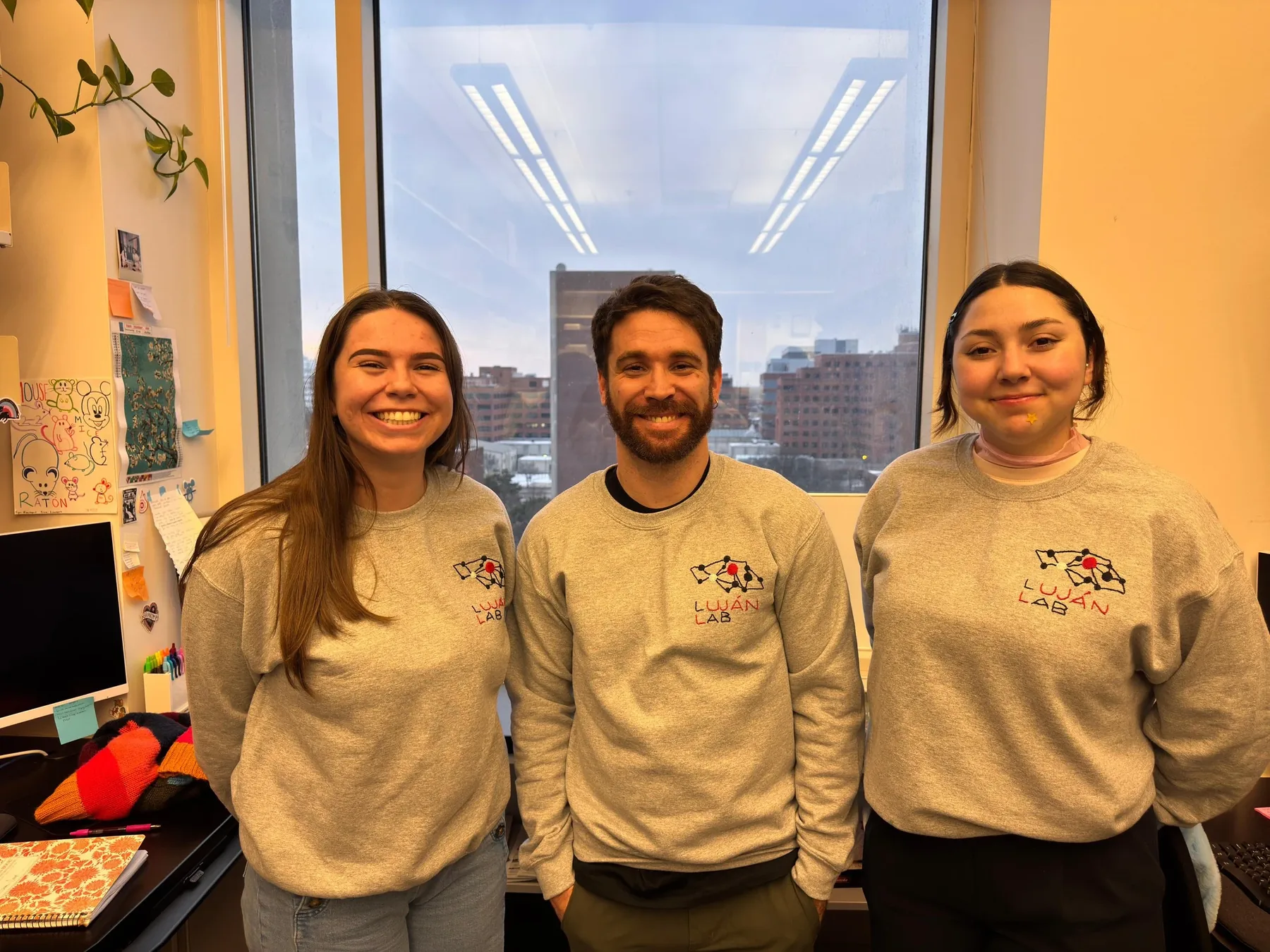 Three lab members in matching lab sweatshirts