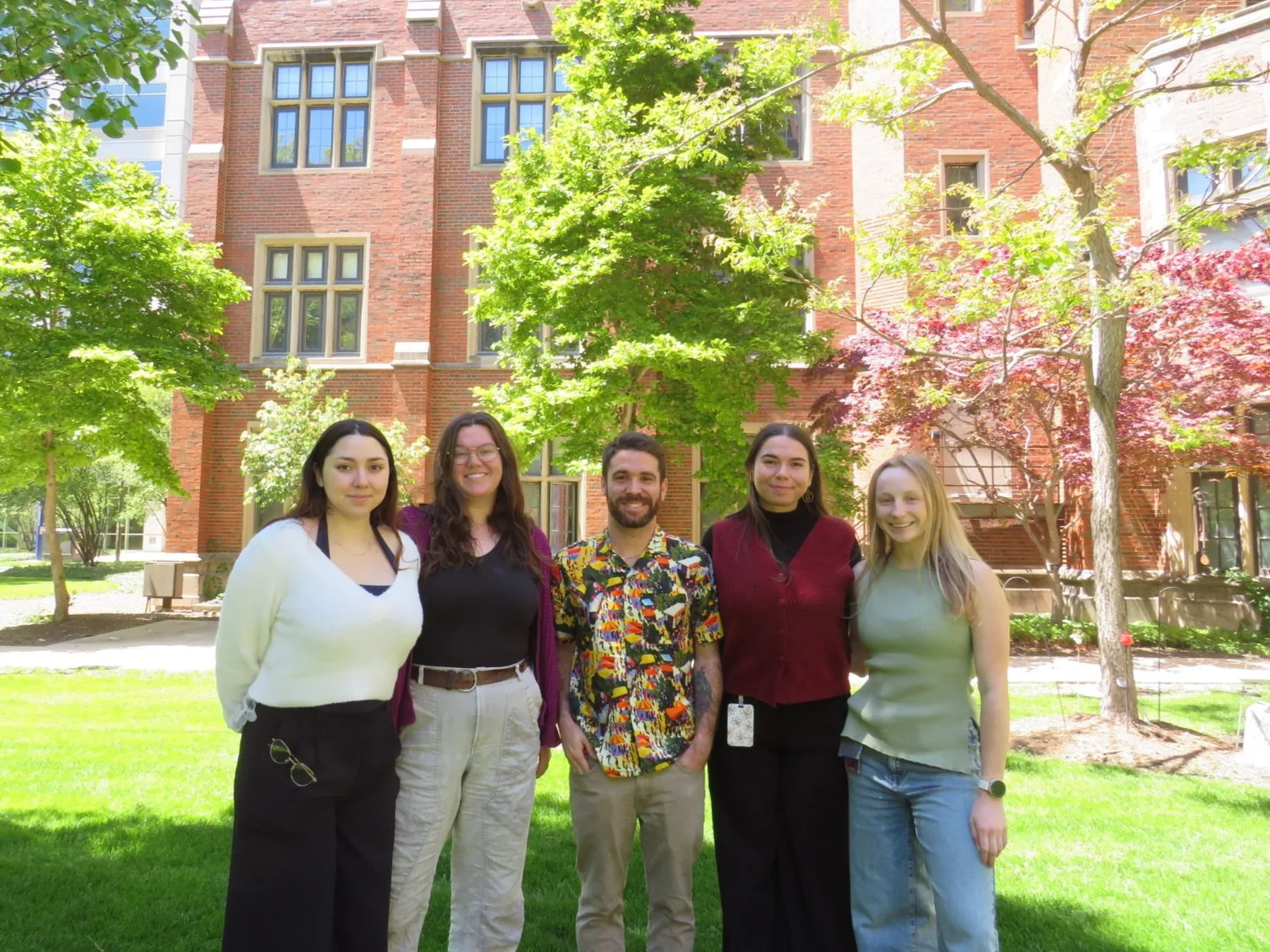 Lab members standing on a lawn in front of a brick building at UIC